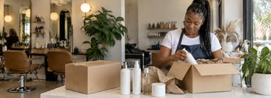 Salon owner unpacking a delivery of professional products at the reception counter.