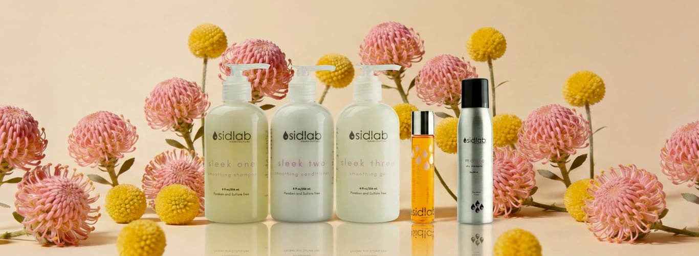 SidLab Haircouture products displayed among pink and yellow flowers, showcasing sleek shampoo, conditioner, and styling formulas.